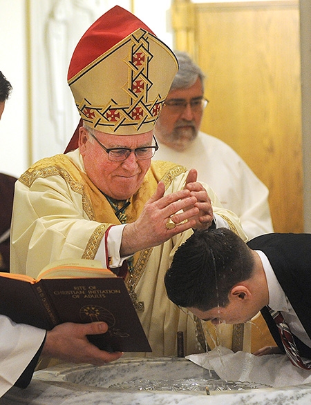 Newly converted Catholic 17-year-old Cameron Socha is baptized by Bishop Richard J. Malone during the Easter Vigil Mass at St. Joseph Cathedral. (Dan Cappellazzo/Staff Photographer)